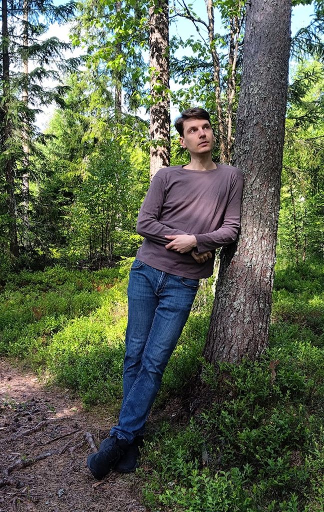Mies nojaa rennosti puuta vasten